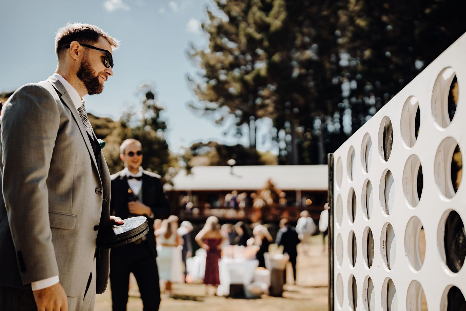 Wedding guests enjoying outdoor lawn games with giant Connect Four set.