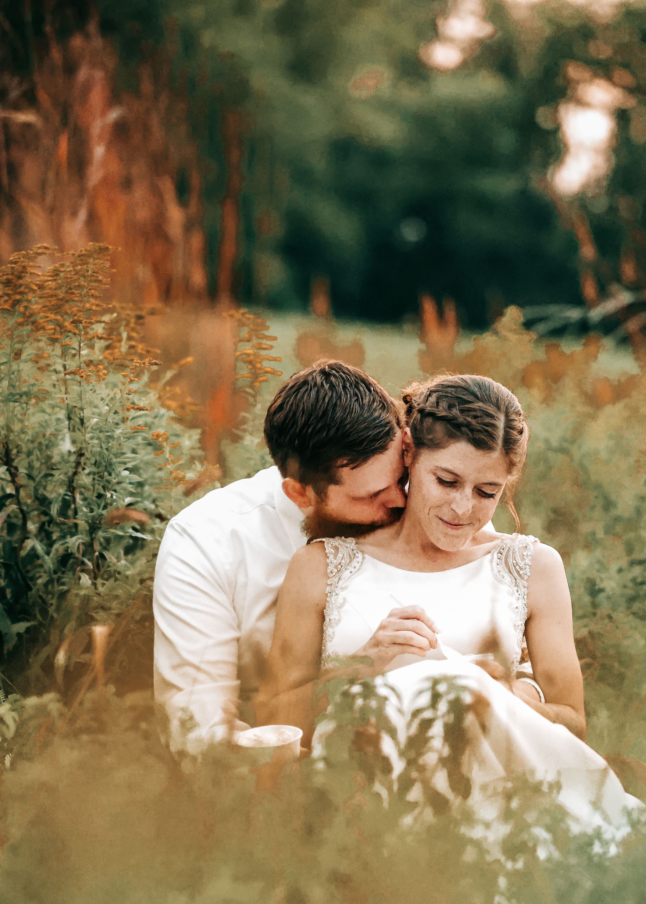 A romantic moment captured in a field with warm sunlight filtering through.