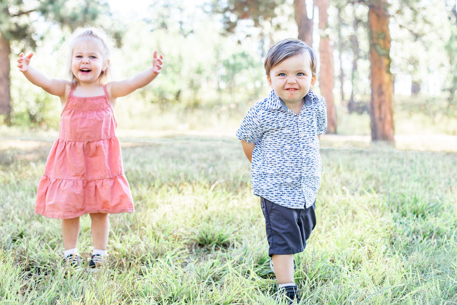 Toddler cousins play in the grass together in Black Forest, Colorado.