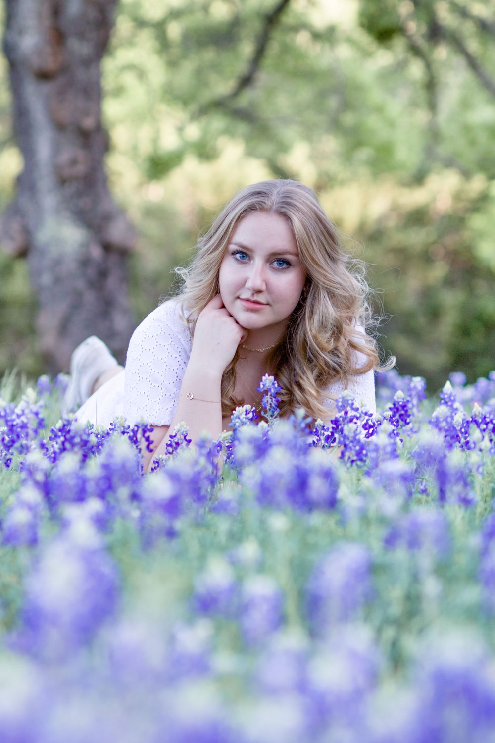 Artistic portrait in a field of blooming purple wildflowers with soft natural lighting.