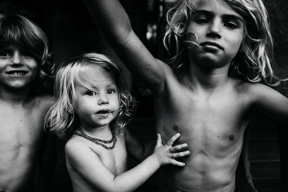 Dramatic black and white portrait of children with expressive faces.