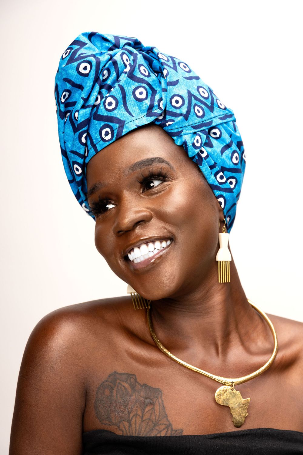 Portrait series showing person in blue patterned headwrap and gold jewelry against white background.