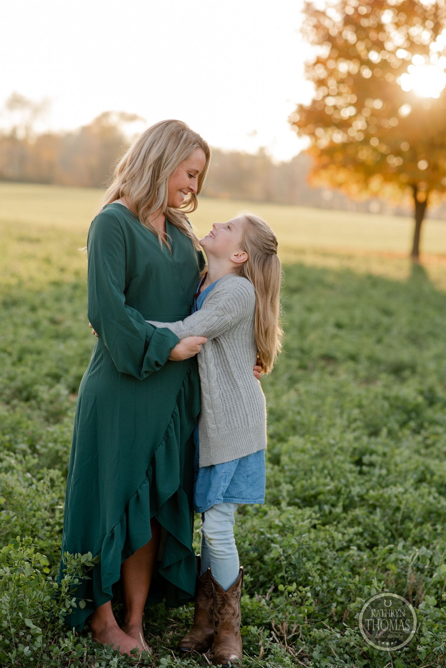 A tender moment between two people in a green field during golden hour.