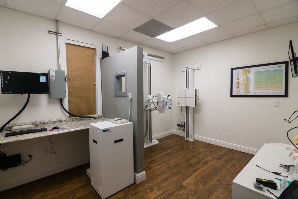Modern medical examination room with equipment, monitors and wood flooring.