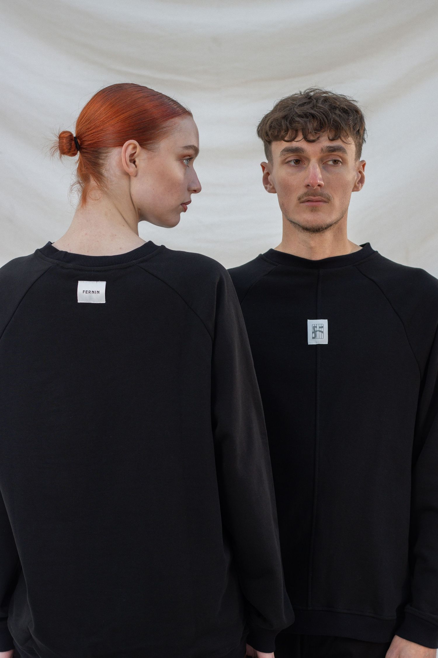 Een man en een vrouw in zwarte kleding geposeerd.