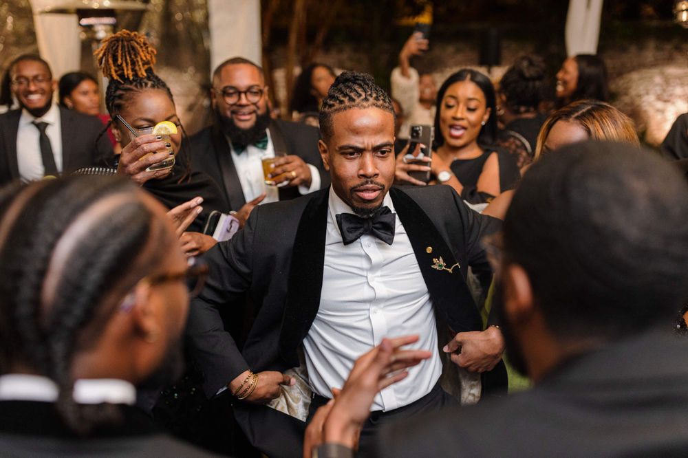 Wedding guests dancing and celebrating during a lively reception party.