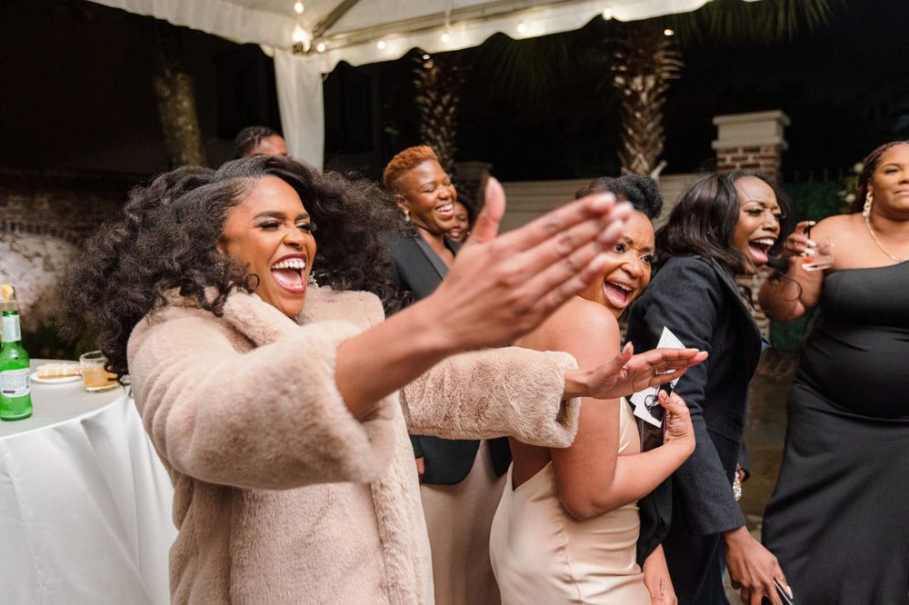 Joyful wedding guests celebrating with expressive dance moves at a reception.