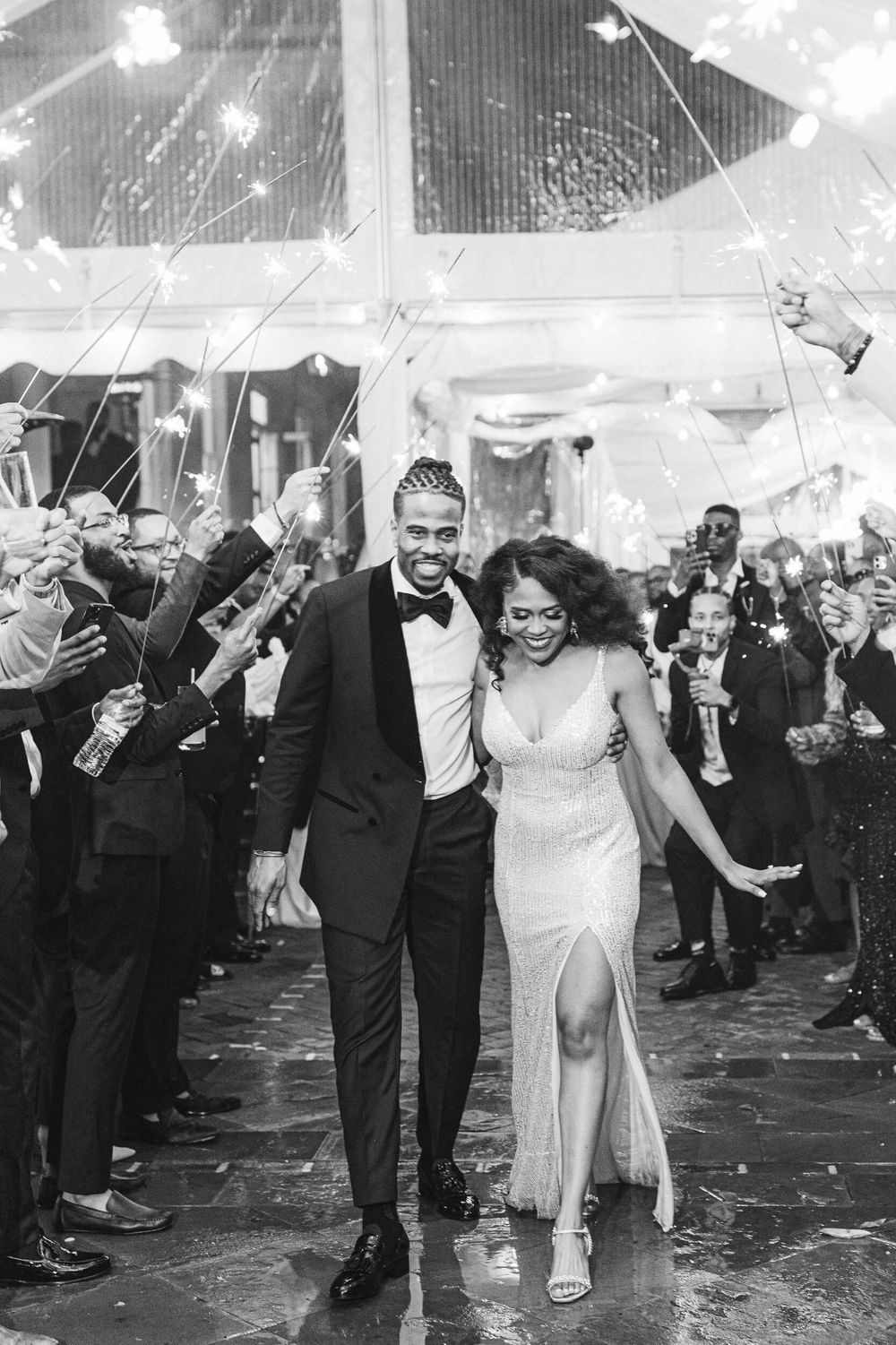 Newlyweds make their grand exit under sparklers at wedding reception.