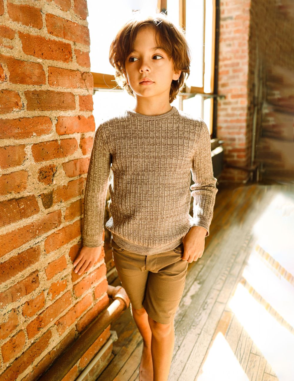 Natural light studio photo of a teen modeling for a clothing brand. Boy's fashion photo.