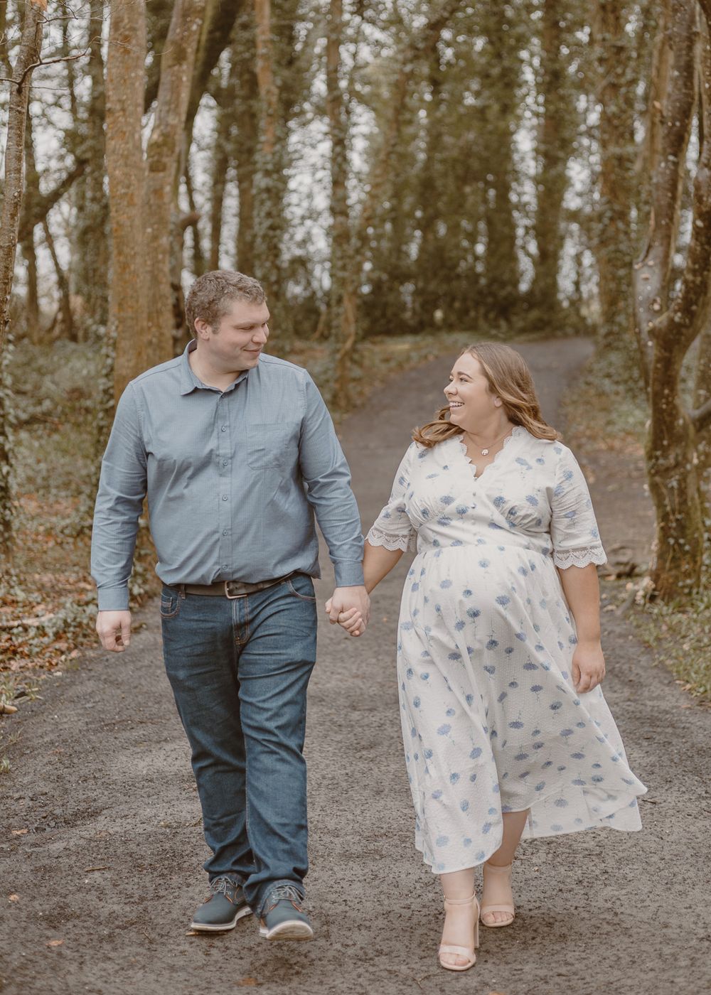 maternity photoshoot of mum and dad walking in the forest
