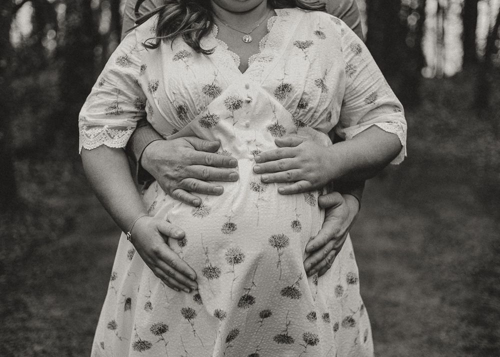 Black and white maternity photo of mum & dad holding the belly