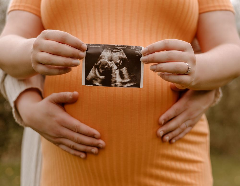 maternity photoshoot of mum holding ultrasound scan