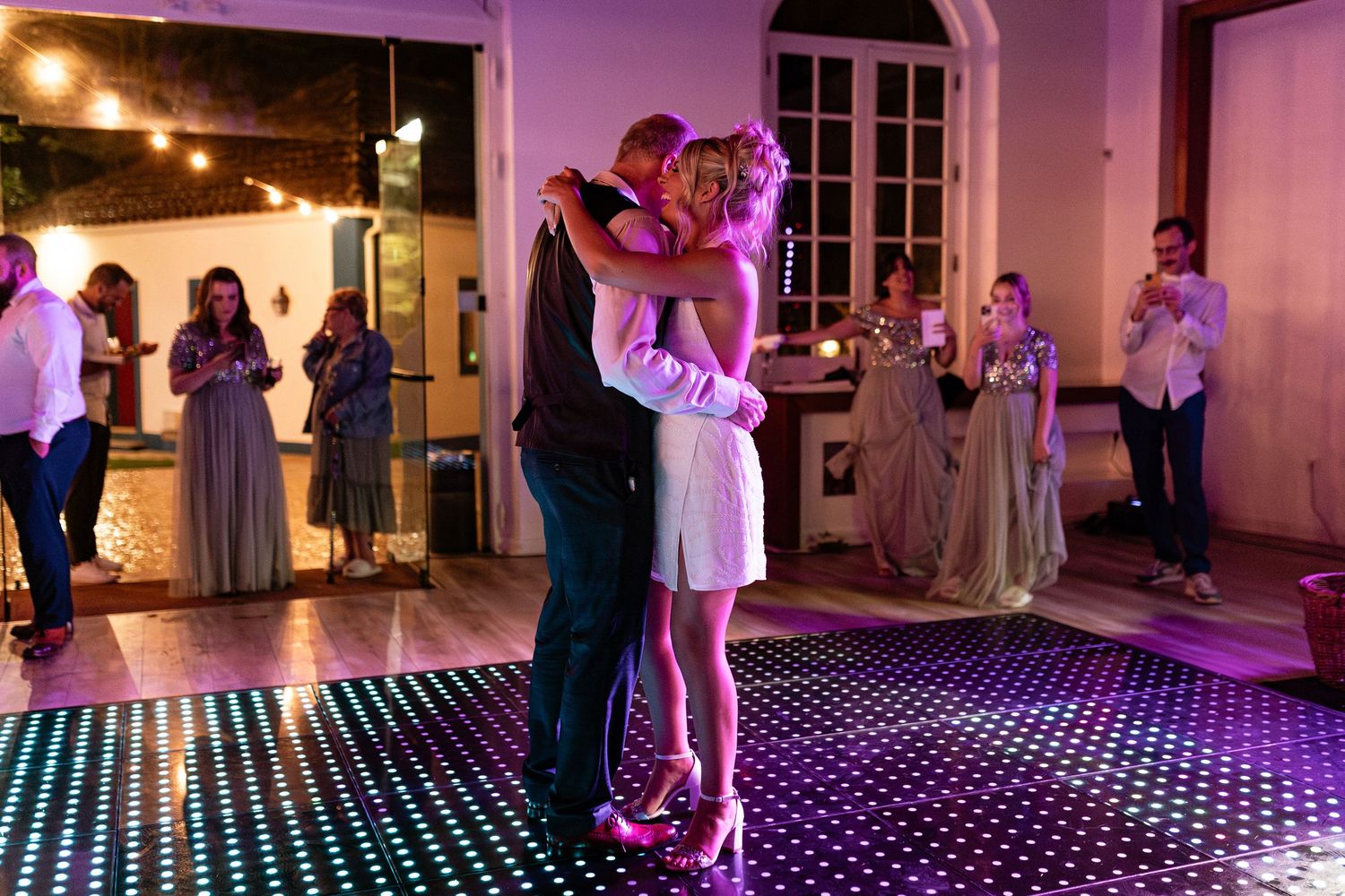 wedding photo shows a bride dancing with her father at dance floor