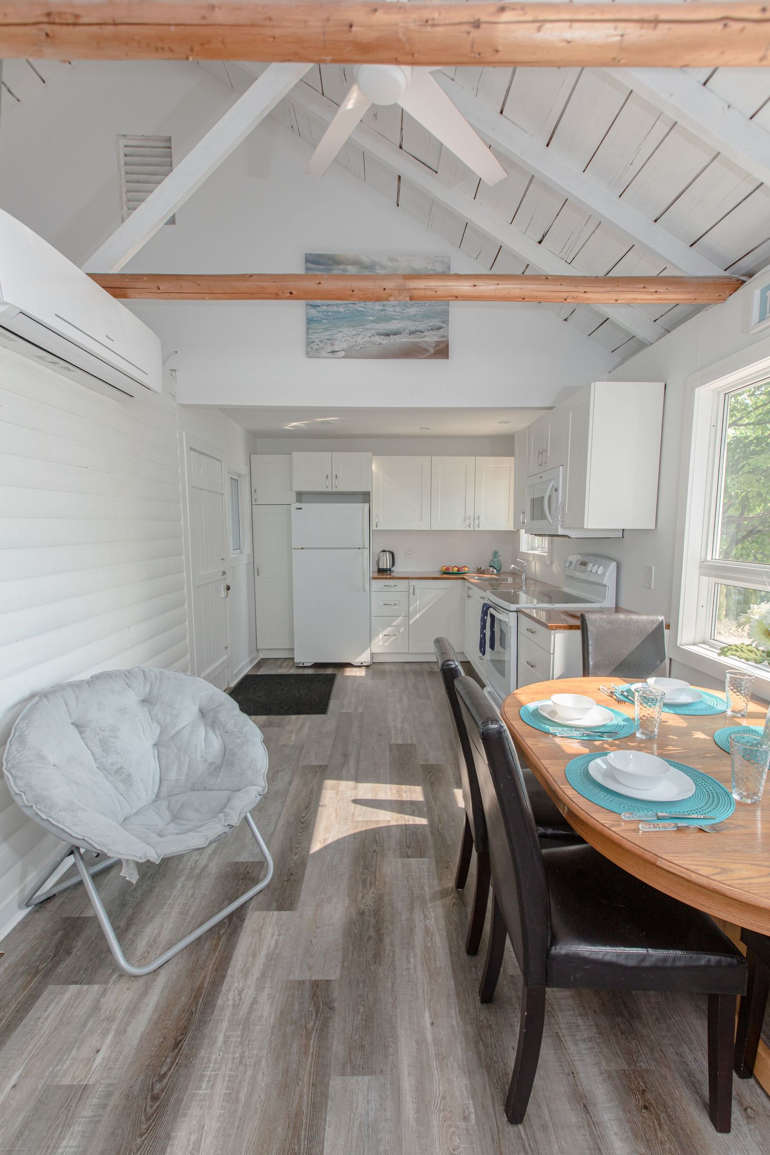Modern cottage kitchen with vaulted ceilings, wood floors, and a dining area flooded with natural light.