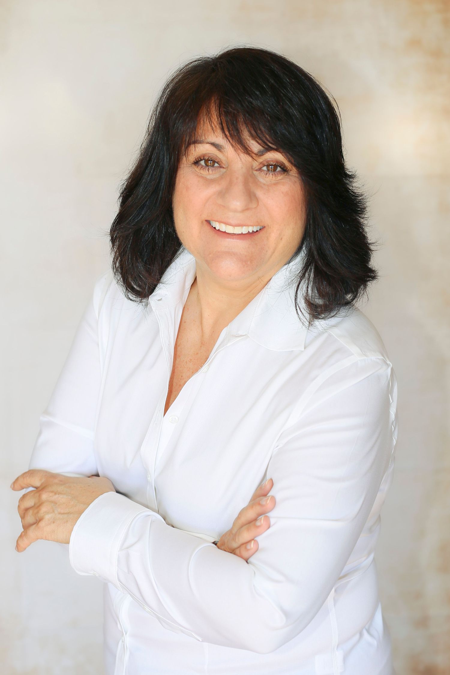 real estate photo headshot brown haired woman crossing her arms
