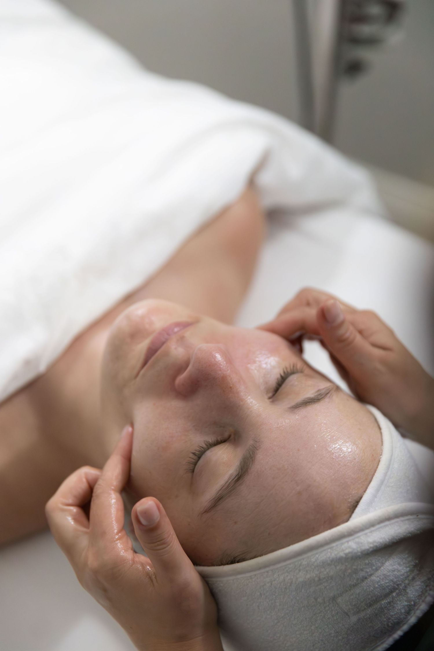 Relaxing facial massage being performed in spa setting.