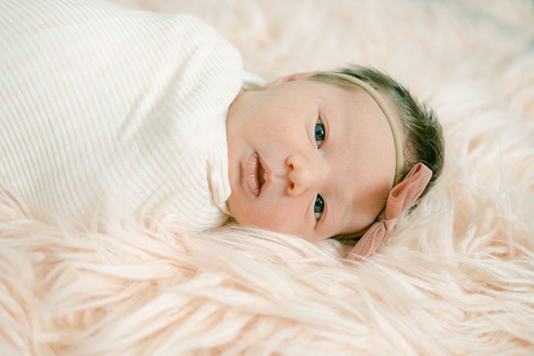 newborn baby girl on the rug in Salt Lake City Utah for lifestyle photos.