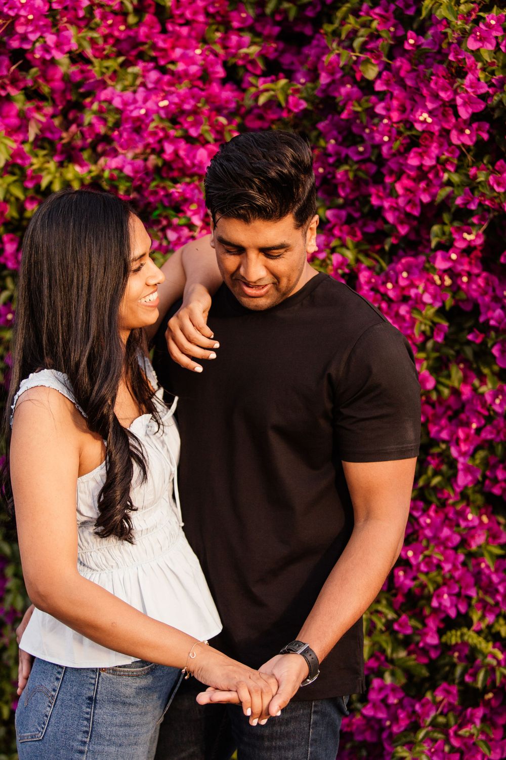 couple posing in front of flowers
