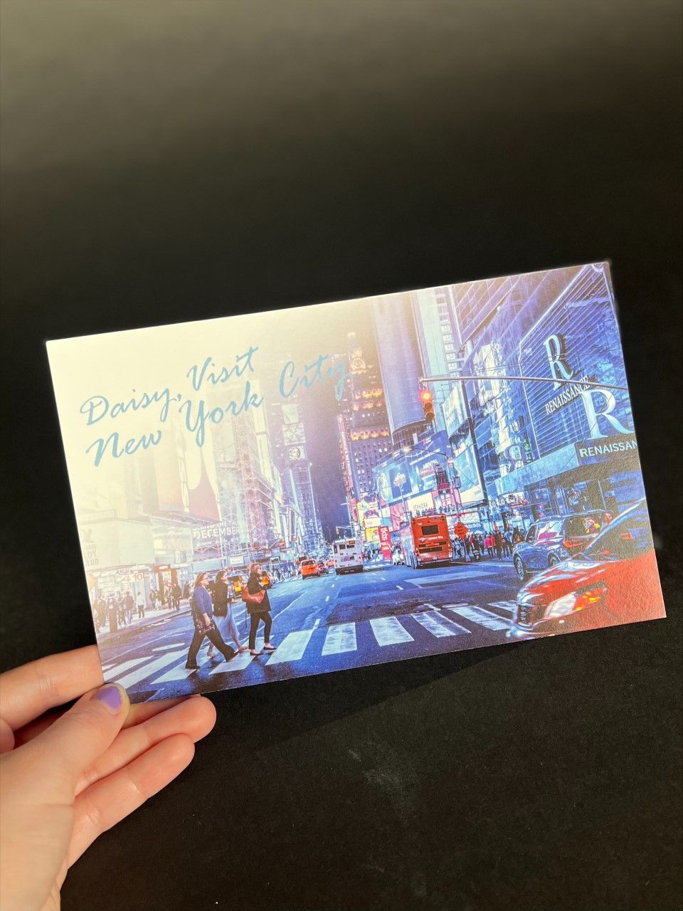 hand holding new york city postcard