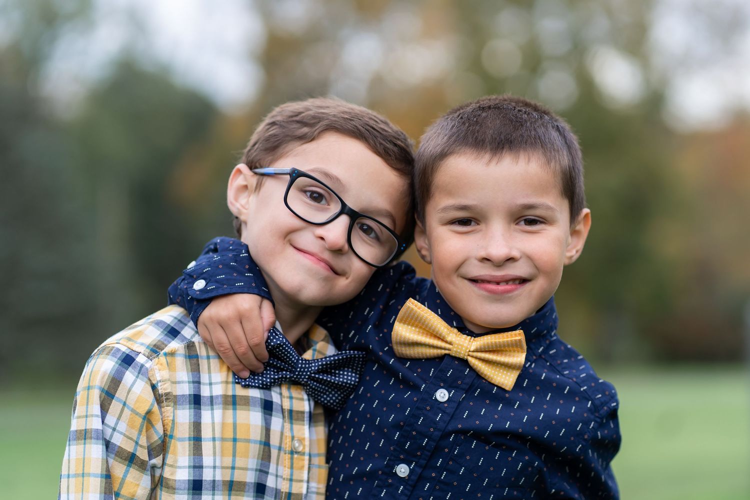 7 year old twin boys wearing bow ties hug each other
