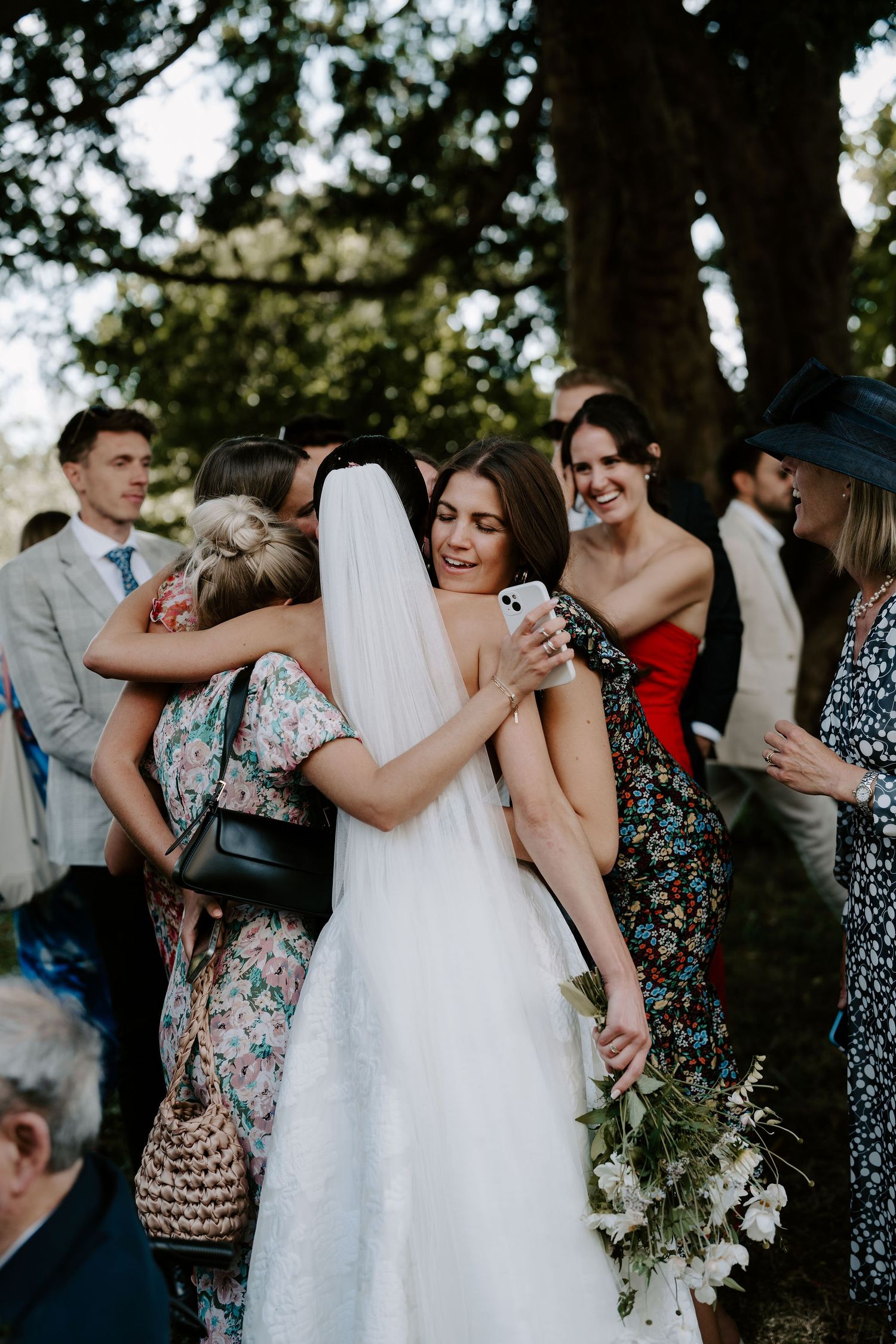 bride hugging wedding guest at st Nicholas church in Oxfordshire