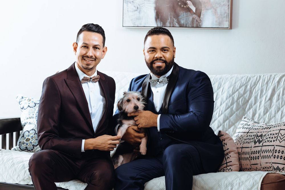 Cozy home portrait of couple on white couch with small dog.