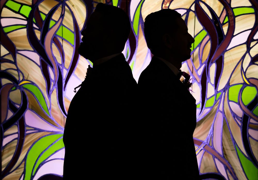 Abstract art silhouettes against a vibrant swirling background of purple and green colors.