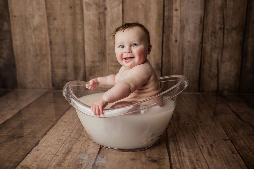 Vintage-style photo shoot with white ceramic basin against rustic wooden background.