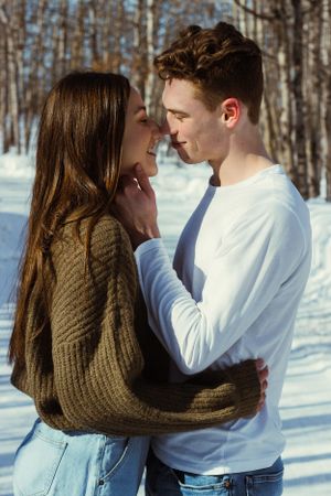 A couple stare at each other, about to kiss. The man's hands are on her face and the woman's hands are on his waist.