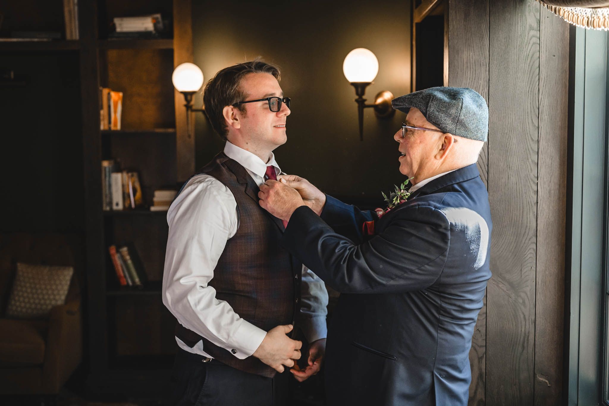 An intimate moment captured between two people in formal attire near a window.