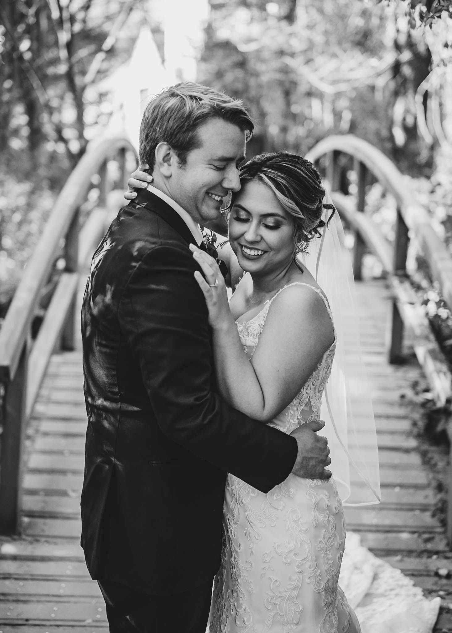 Couple shares intimate dance moves on a wooden walkway surrounded by trees.