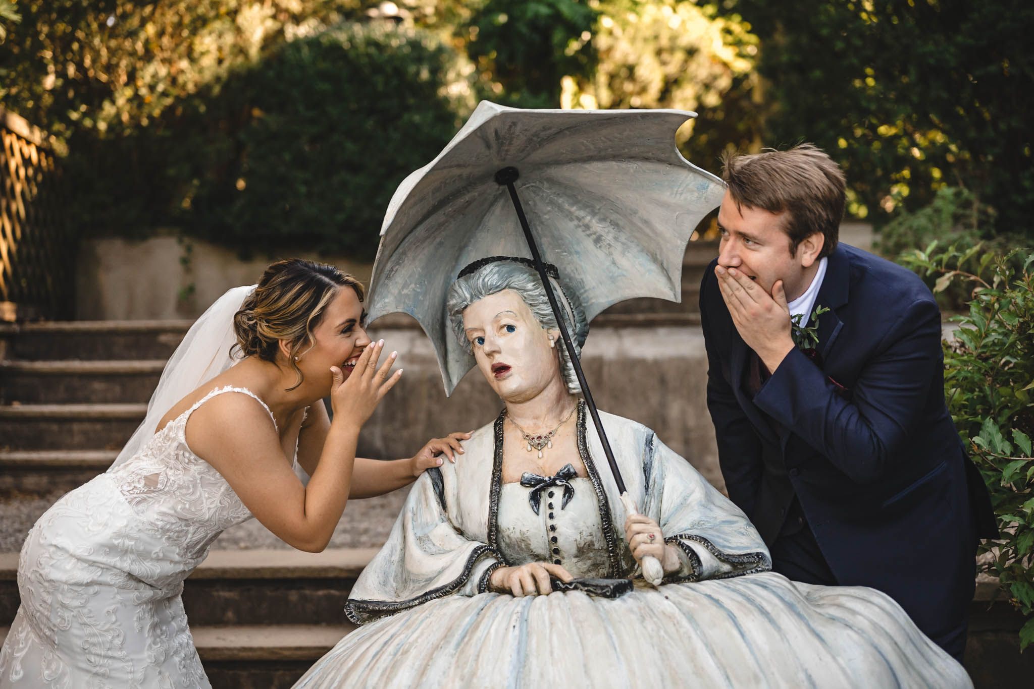 Playful wedding moments captured on a garden pathway during golden hour.