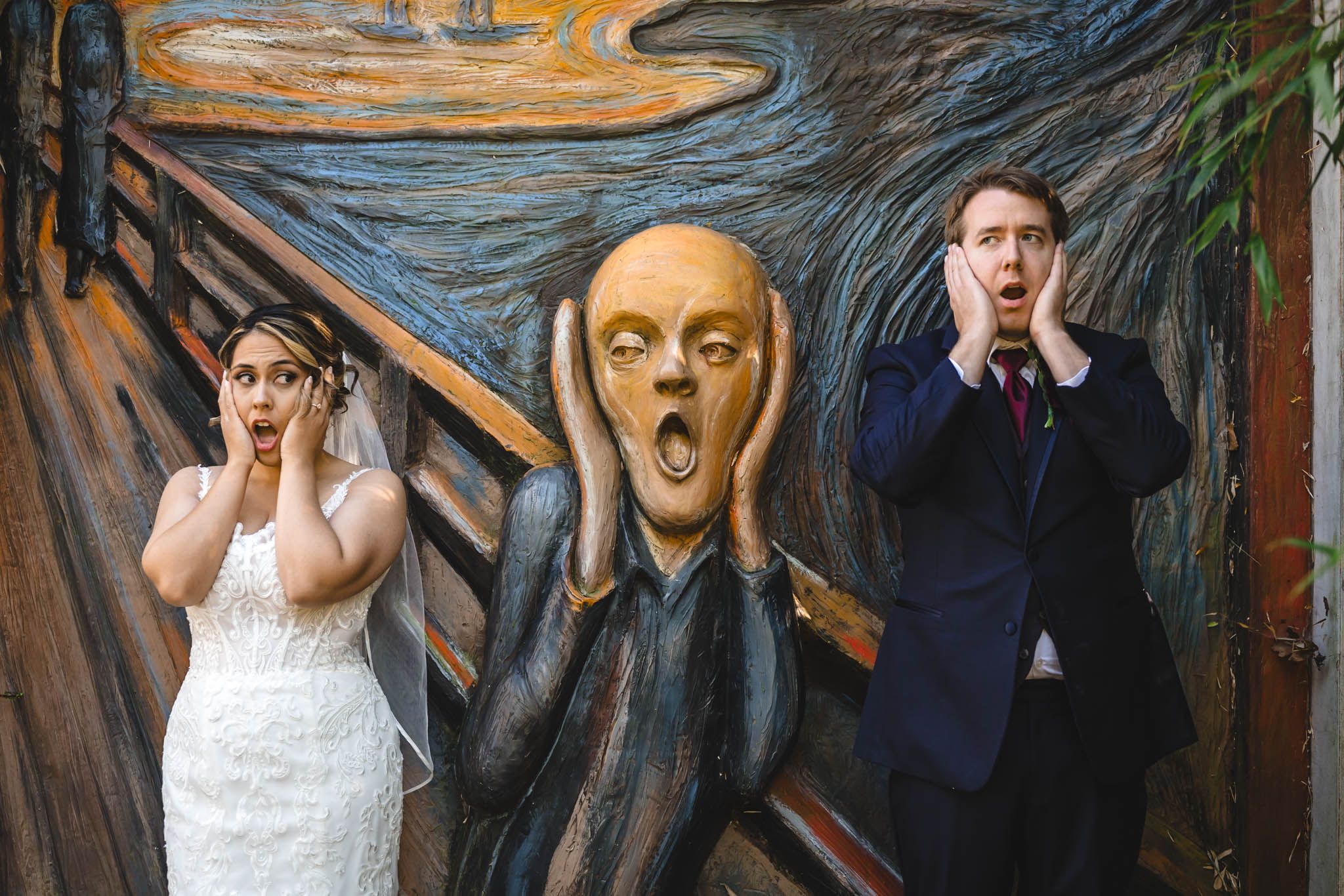 Creative wedding portraits with dramatic expressions against artistic backdrop.