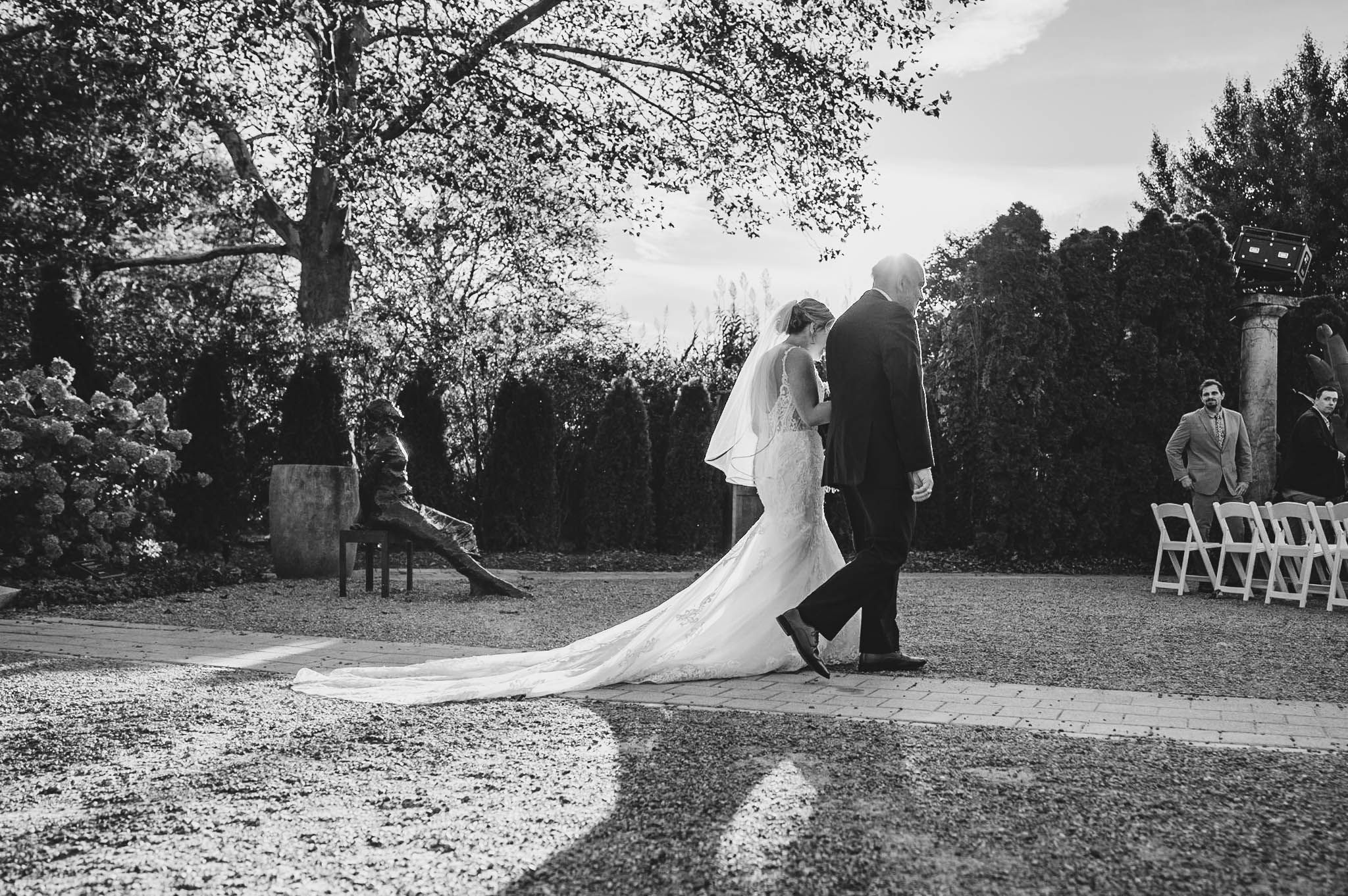 Black and white photograph of a garden wedding ceremony with guests seated outdoors.