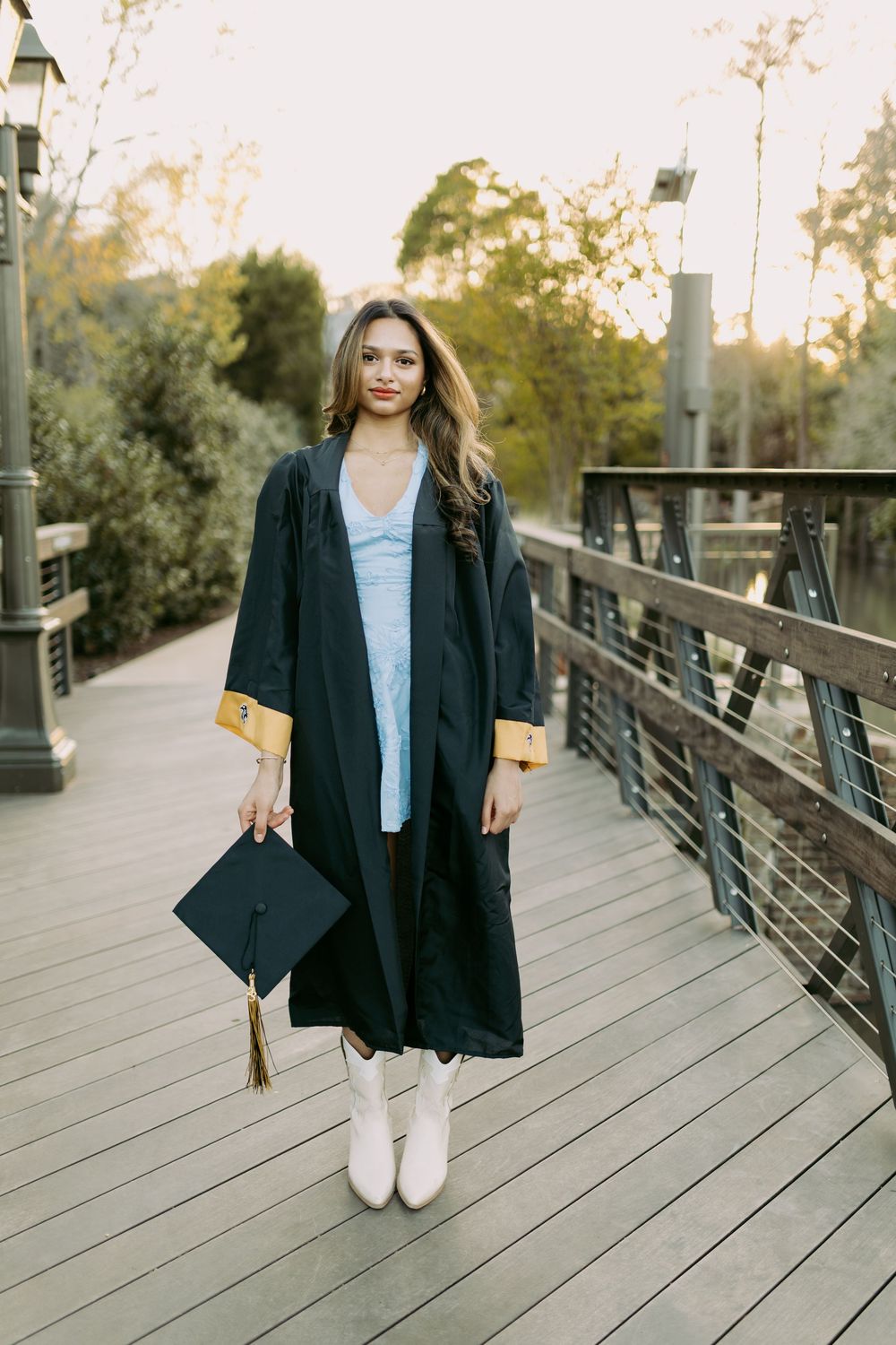A series of photos showing someone in a navy blazer and white shoes posing on a wooden boardwalk at sunset.