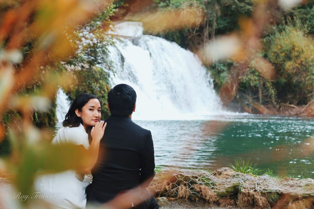A romantic waterfall scene framed by autumn foliage creates a dreamy backdrop.