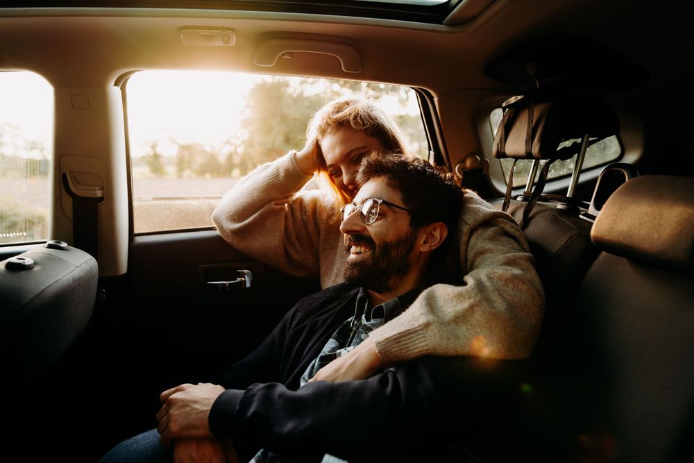 Relaxed moment in car backseat with warm sunlight streaming through window.