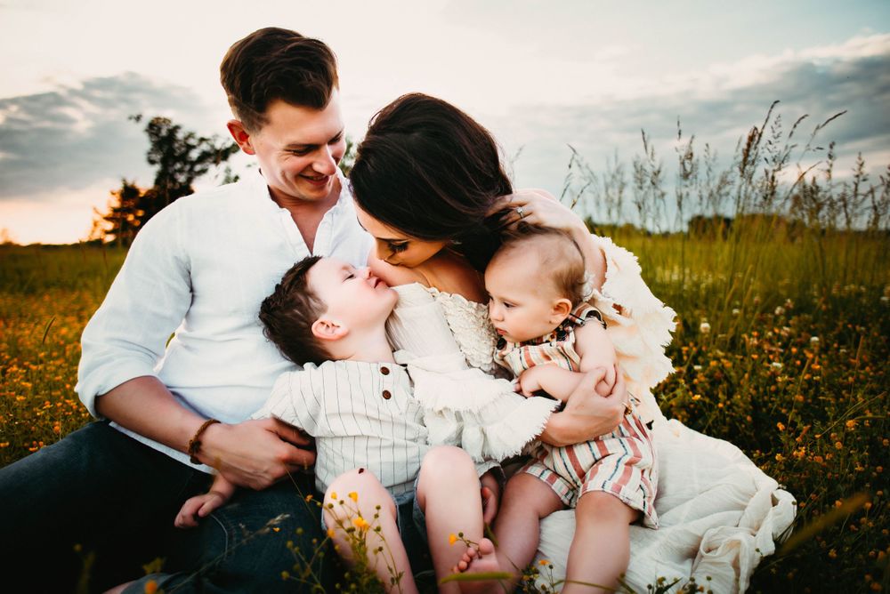 Intimate family portraits in flowering meadow during sunset.