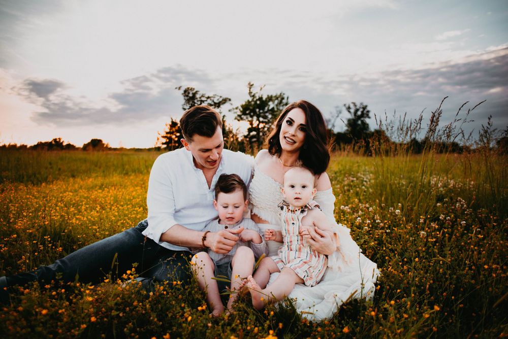 Candid family portrait session in a field of yellow wildflowers during golden hour.