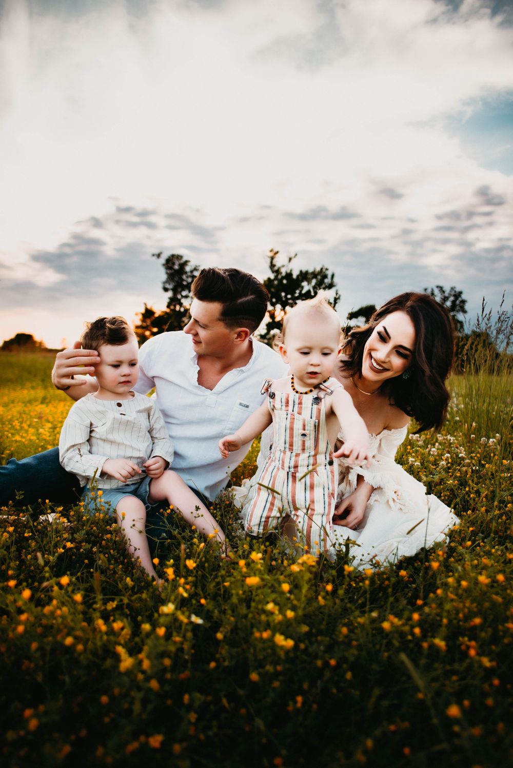 Joyful family moments photographed in a flowering meadow during golden hour.