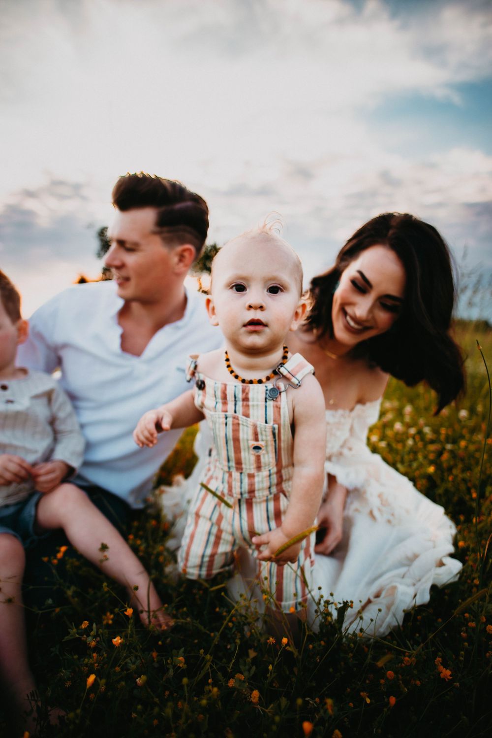 Candid family interactions captured in a wildflower field at sunset.