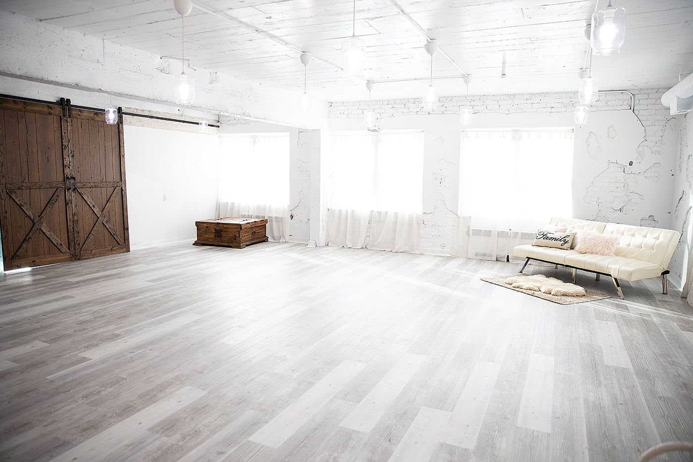 Open concept studio featuring rustic barn doors and contemporary white decor.