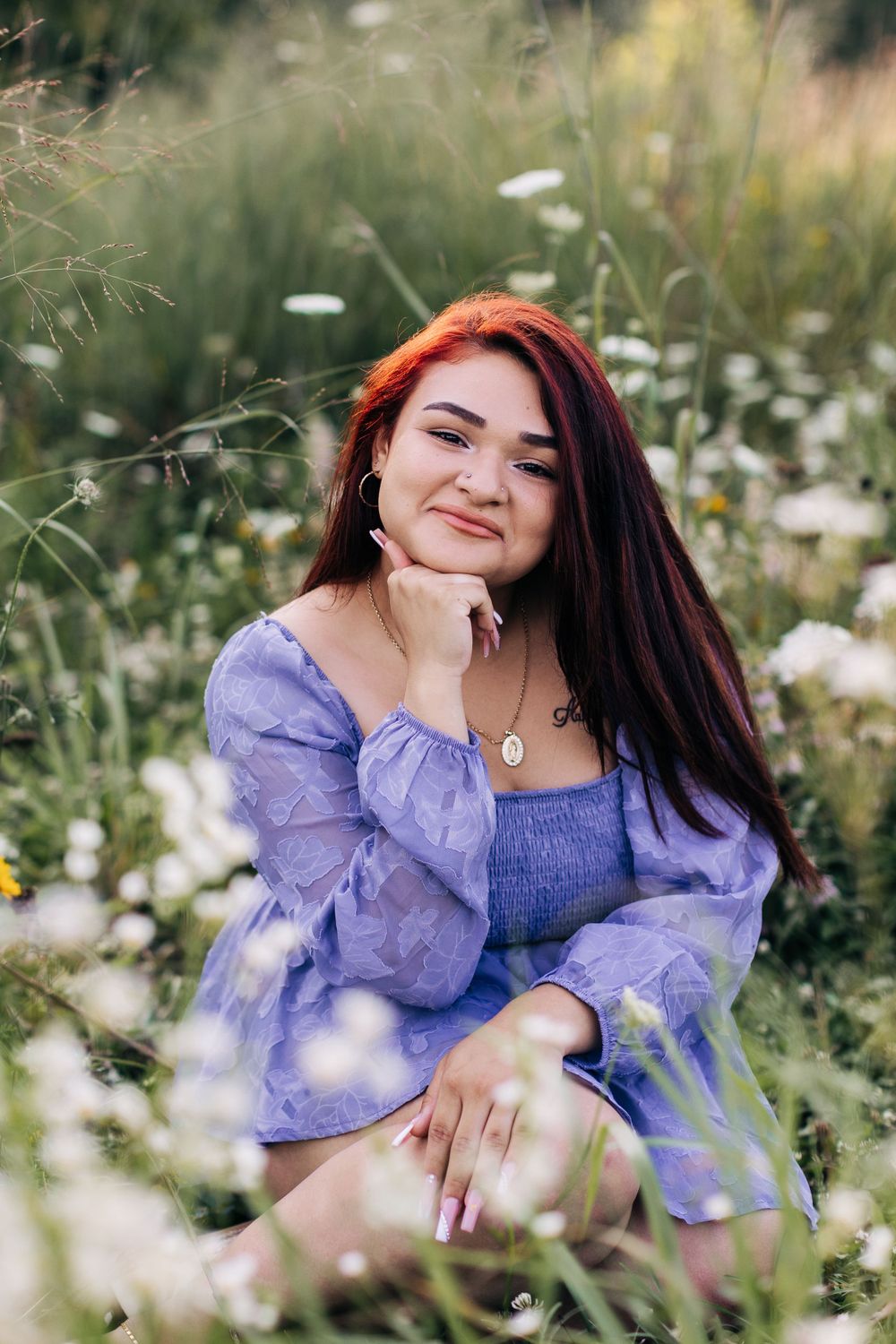 Portrait in purple dress surrounded by white wildflowers and natural greenery.