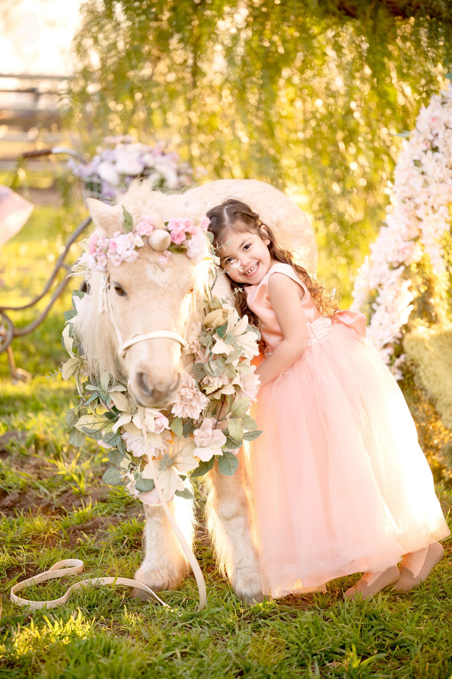 Magical garden moment with flower-adorned white pony and flowing pink dress.