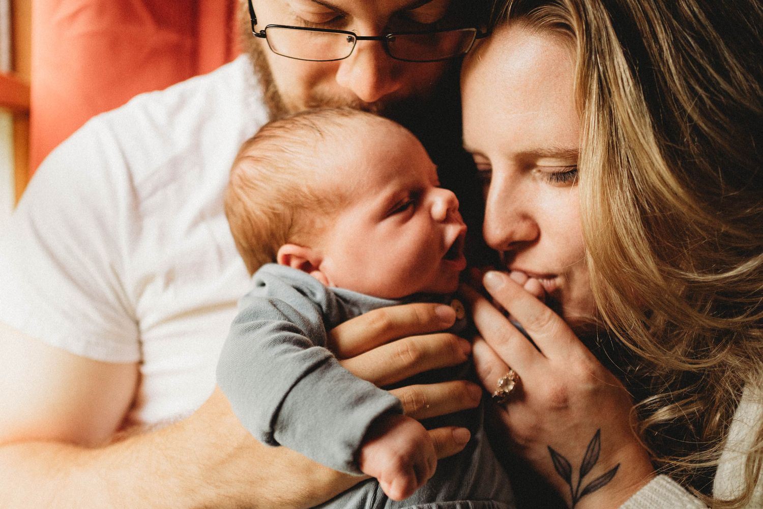 Intimate family portrait showing tender moment with newborn baby.