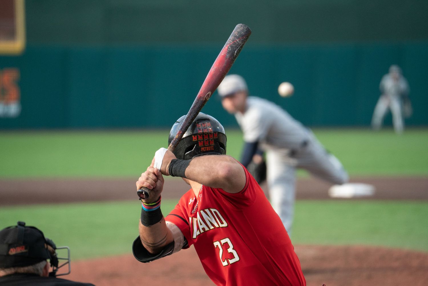 Baseball players in red uniforms at bat during a professional game.
