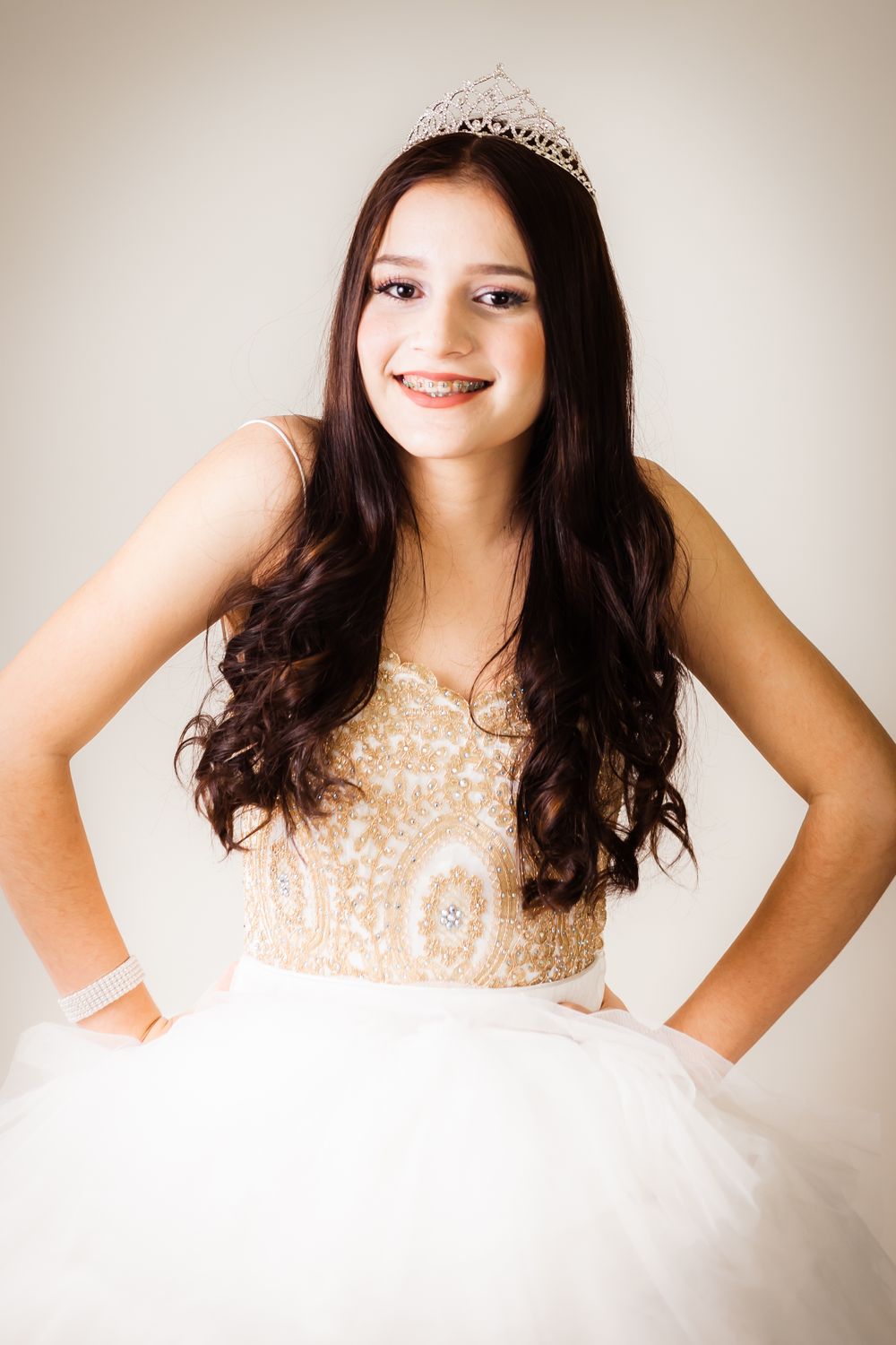 Joyful portrait in a princess-style dress with detailed beadwork and tiara.