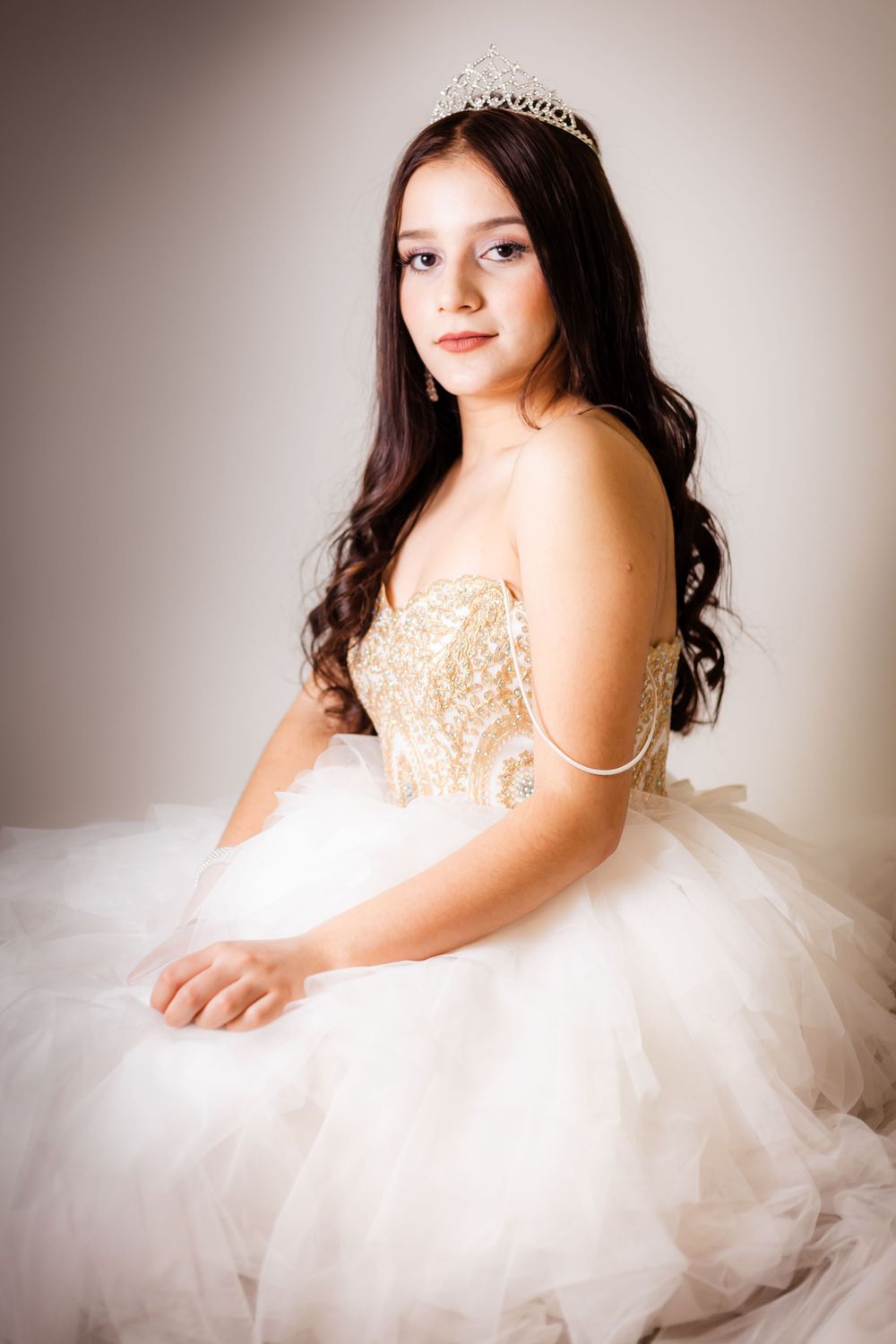 Dreamy portrait in white tulle gown with ornate beading and delicate tiara crown.