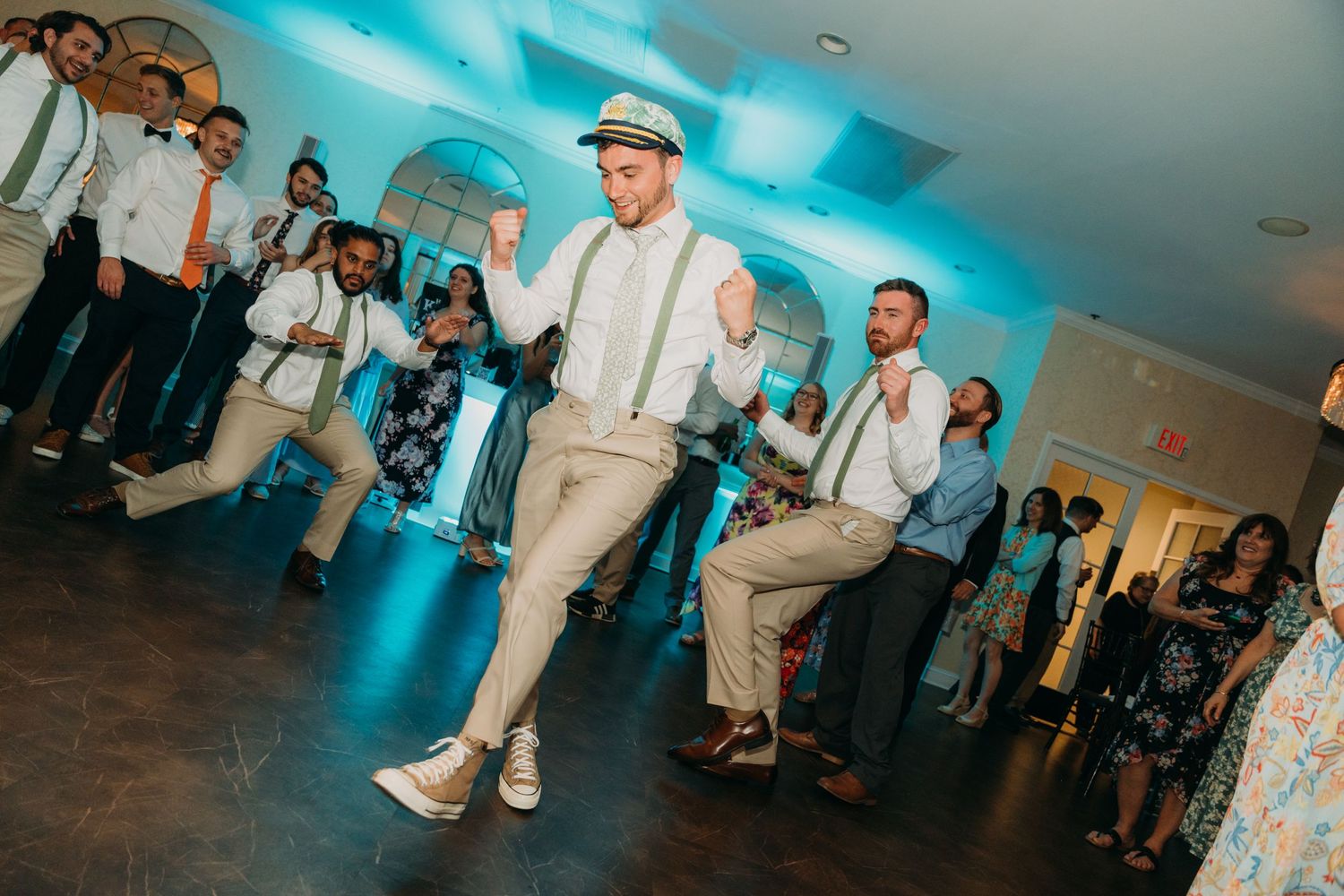 Wedding reception dance floor with blue ambient lighting and guests dancing.