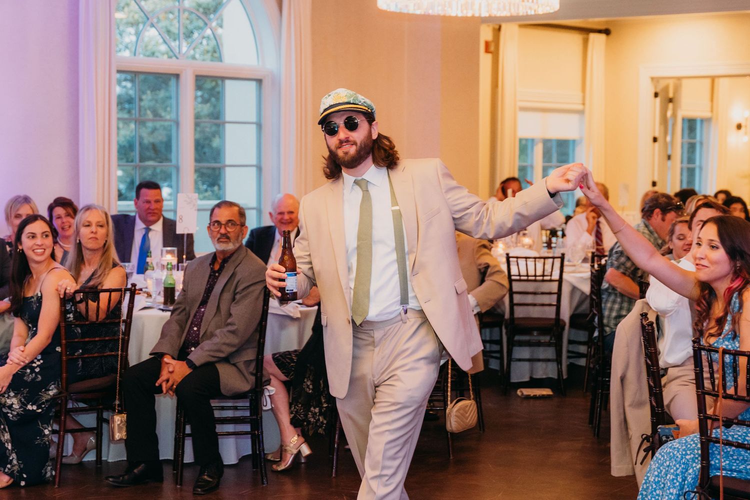 Wedding reception venue with elegant lighting and guests dancing.